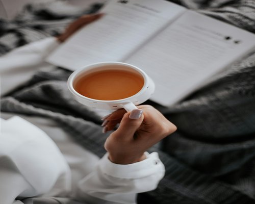 Hands holding a warm cup of tea during a break